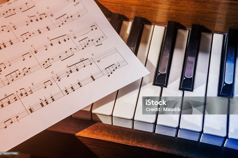 Piano keys and sheet music in cool blue and warm orange